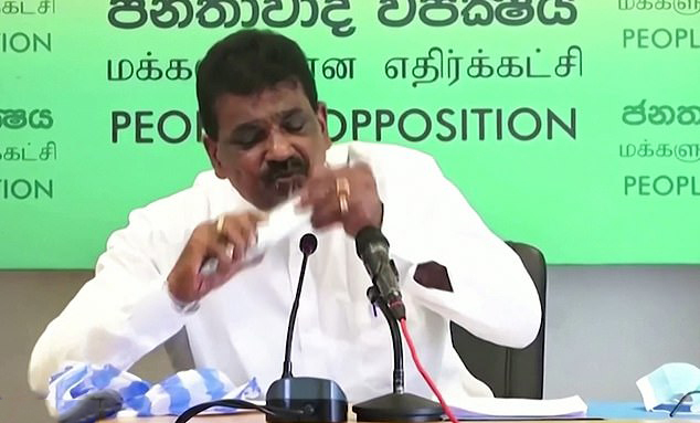 Bizarre moment Sri Lankan politician bites into raw fish to prove it won’t give you Covid after conspiracy frenzy