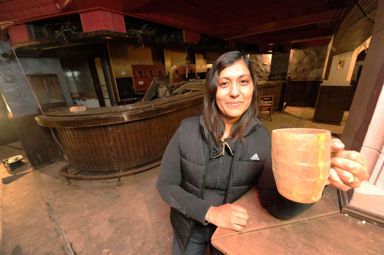 Inside pub frozen in time with empty pint glasses and bag of peanutstrapped underneath busy shopping centre