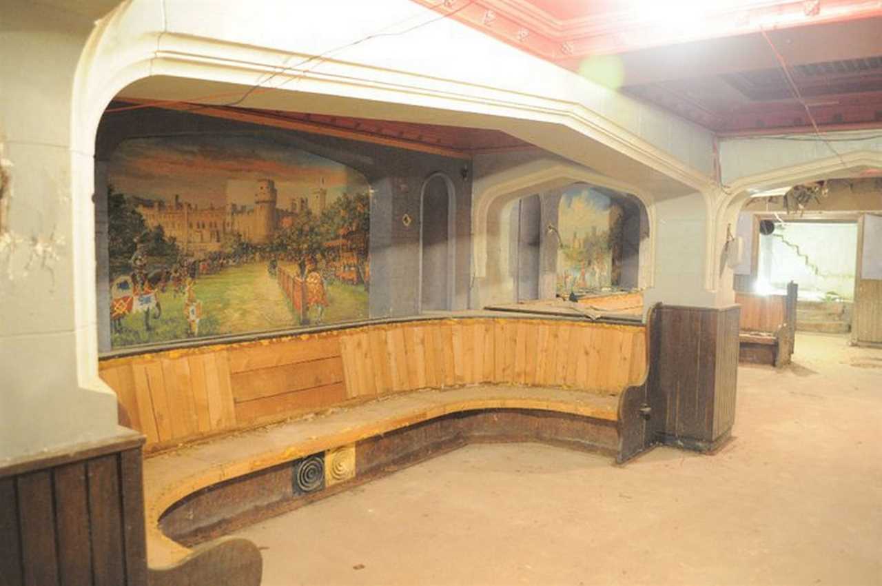 Inside pub frozen in time with empty pint glasses and bag of peanutstrapped underneath busy shopping centre