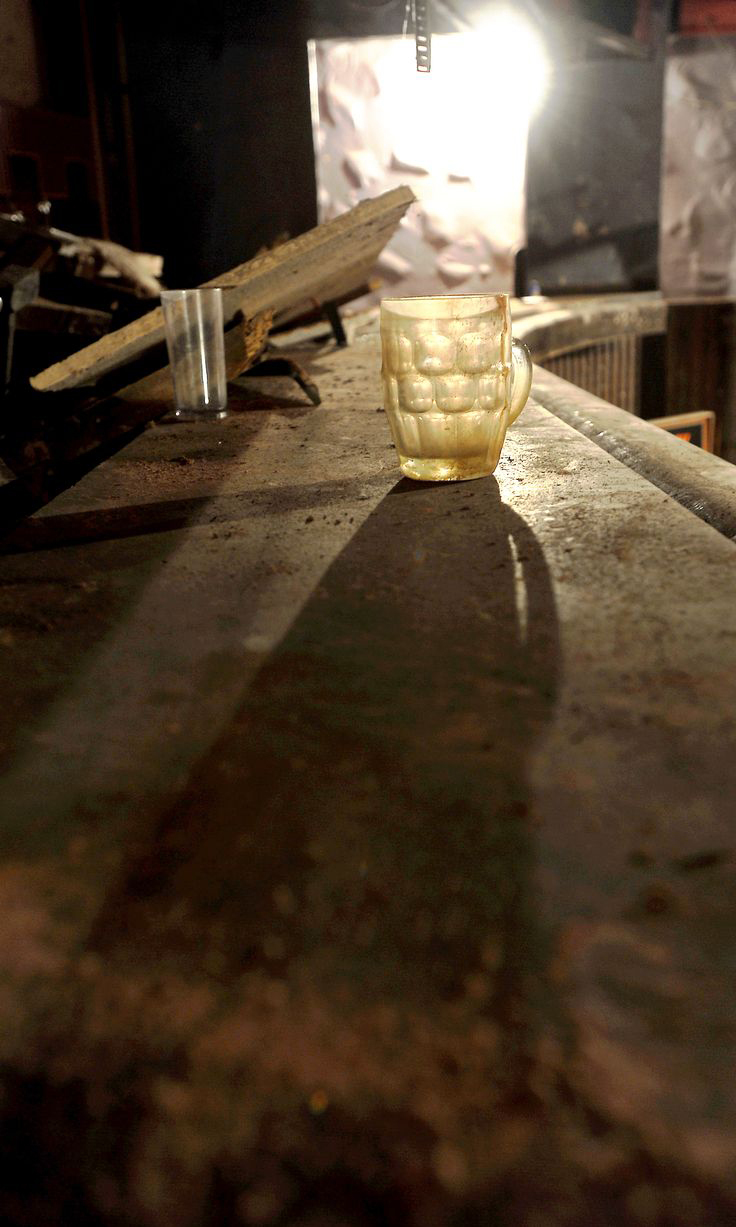 Inside pub frozen in time with empty pint glasses and bag of peanutstrapped underneath busy shopping centre