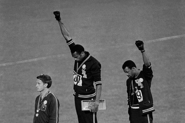 Tommie Smith, center, and John Carlos, right, after Smith received the gold and Carlos the bronze in the 200-meter run at the 1968 Olympics.