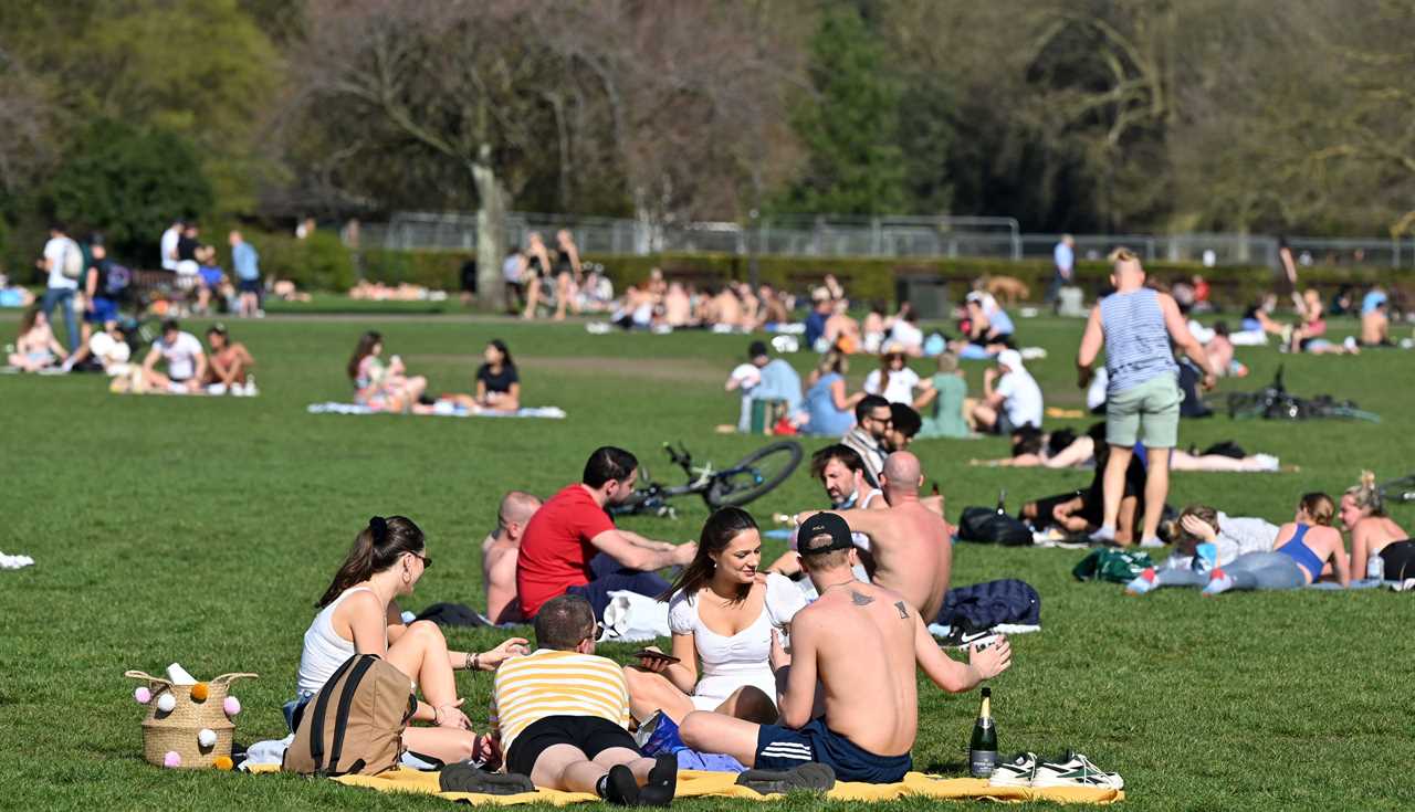 People enjoy the sun in Battersea Park, London