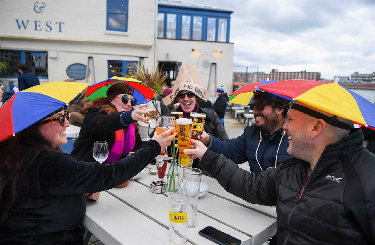 Thirsty Brits brave SNOW & queue from midnight in -3C temperatures as pub beer gardens reopen for first time in months