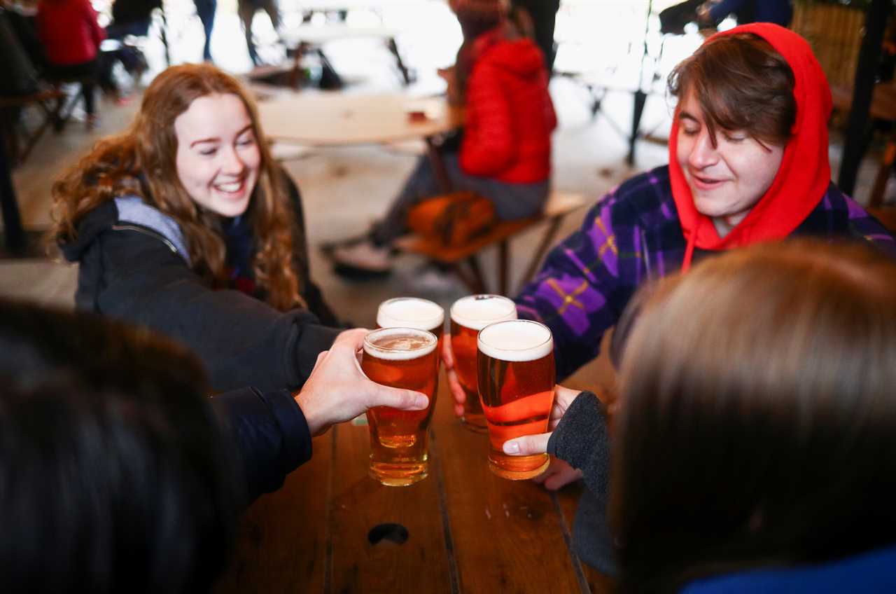 Thirsty Brits brave SNOW & queue from midnight in -3C temperatures as pub beer gardens reopen for first time in months