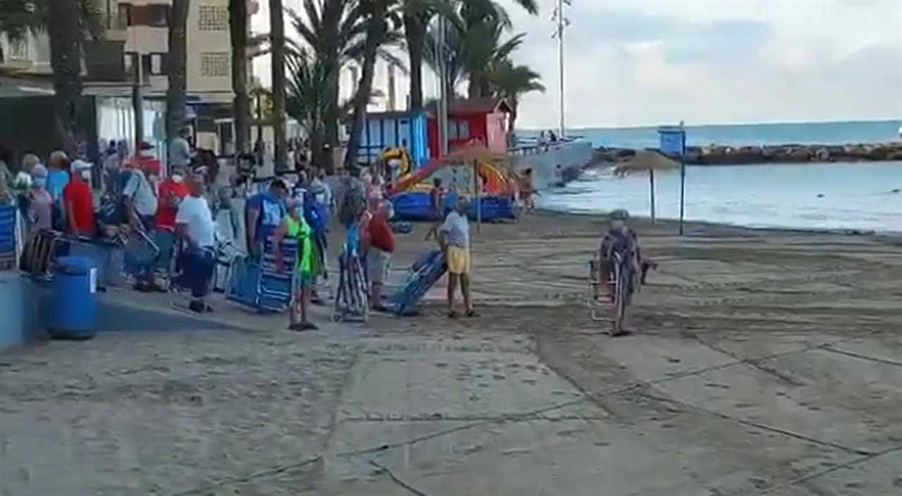 Hilarious moment scores of sunbathers jostle for best socially distanced spots on Alicante beach after queuing from 6am