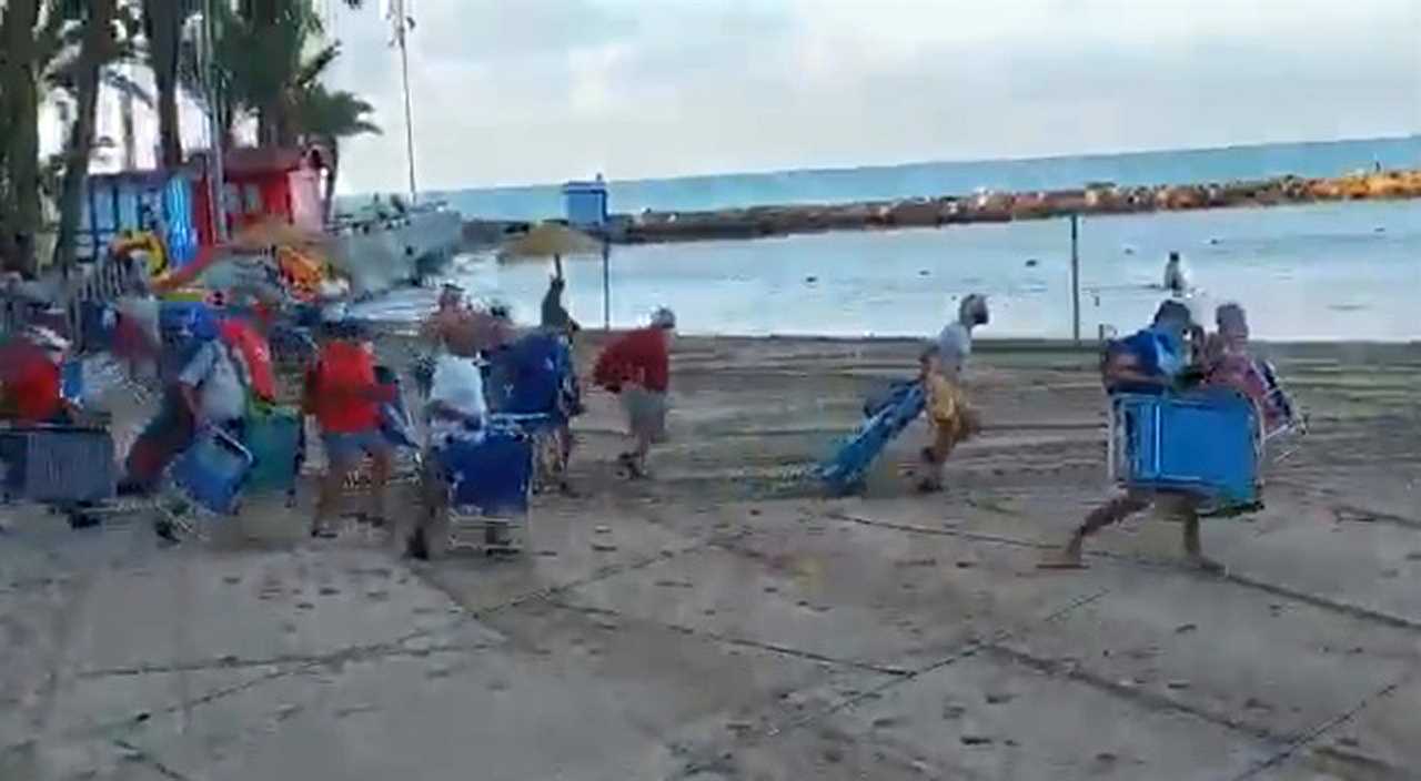 Hilarious moment scores of sunbathers jostle for best socially distanced spots on Alicante beach after queuing from 6am