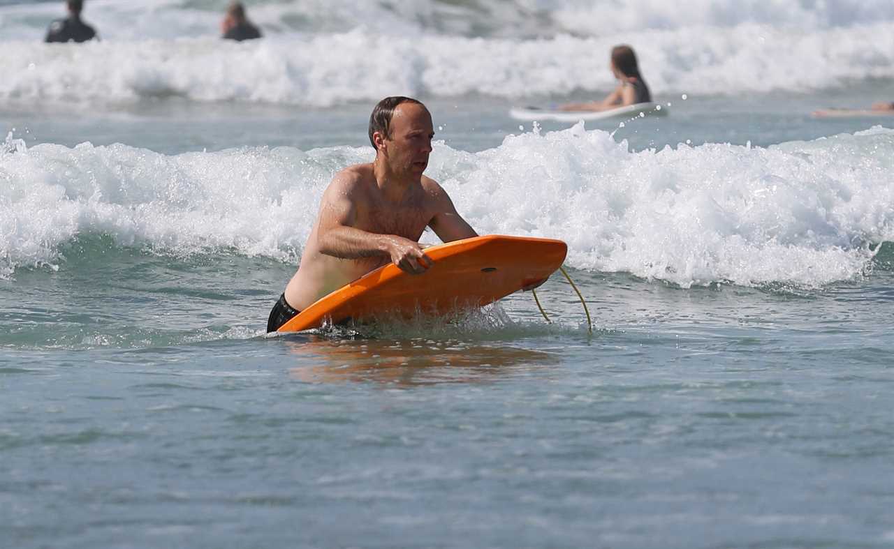 Washed-up Matt Hancock makes a splash with a bodyboard on seaside holiday with his kids and estranged wife Martha