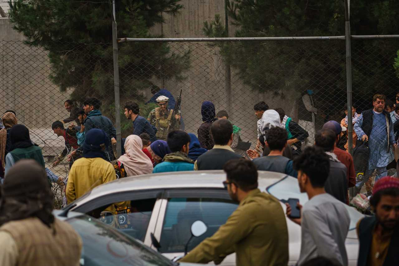 Panic crowds run as Taliban thugs wield their guns outside Kabul airport