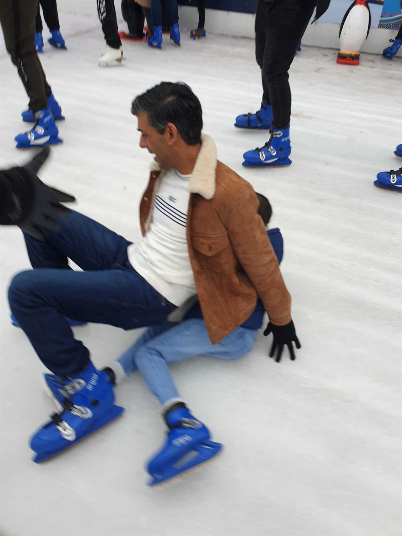 Rishi Sunak squishes daughter as he slips on ice rink during family day out