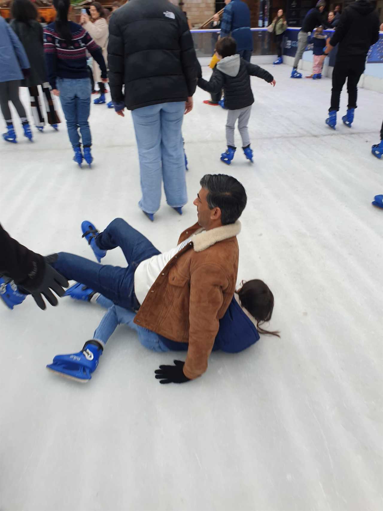 Rishi Sunak squishes daughter as he slips on ice rink during family day out