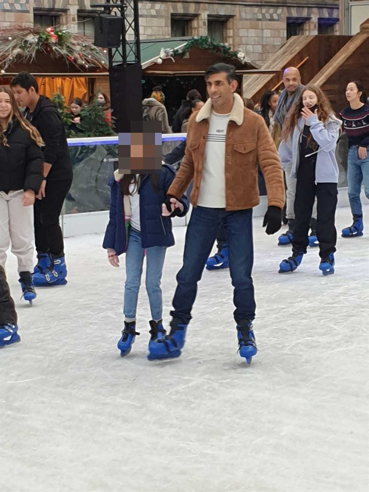 Rishi Sunak squishes daughter as he slips on ice rink during family day out