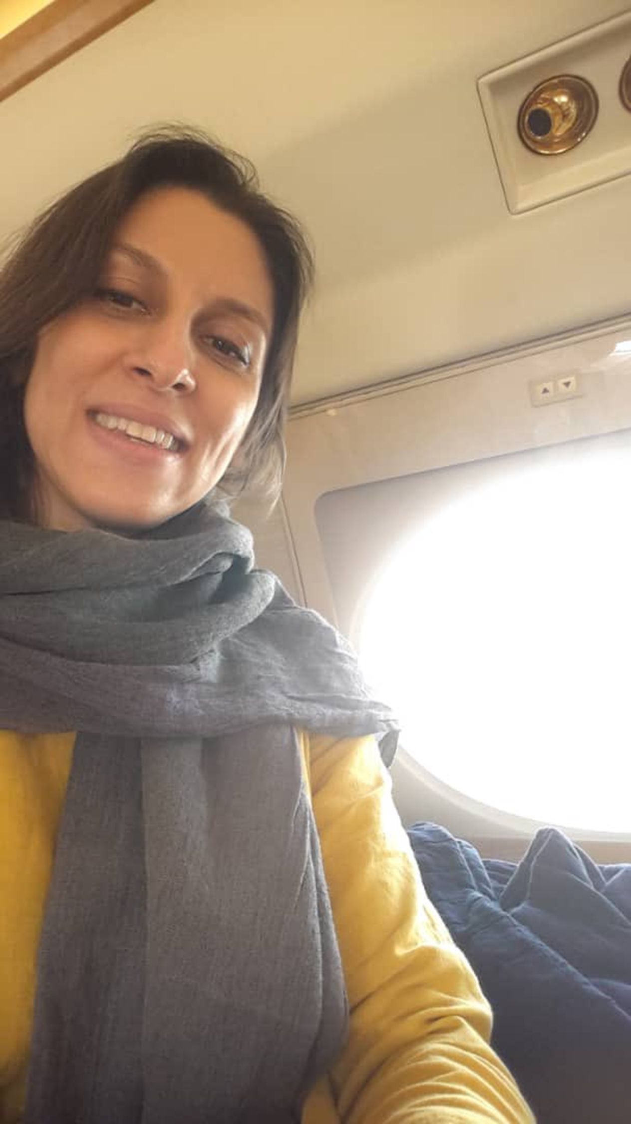 Nazanin Zaghari-Ratcliffe beams from safety of the skies as she heads home to Britain after six years in Iranian jail