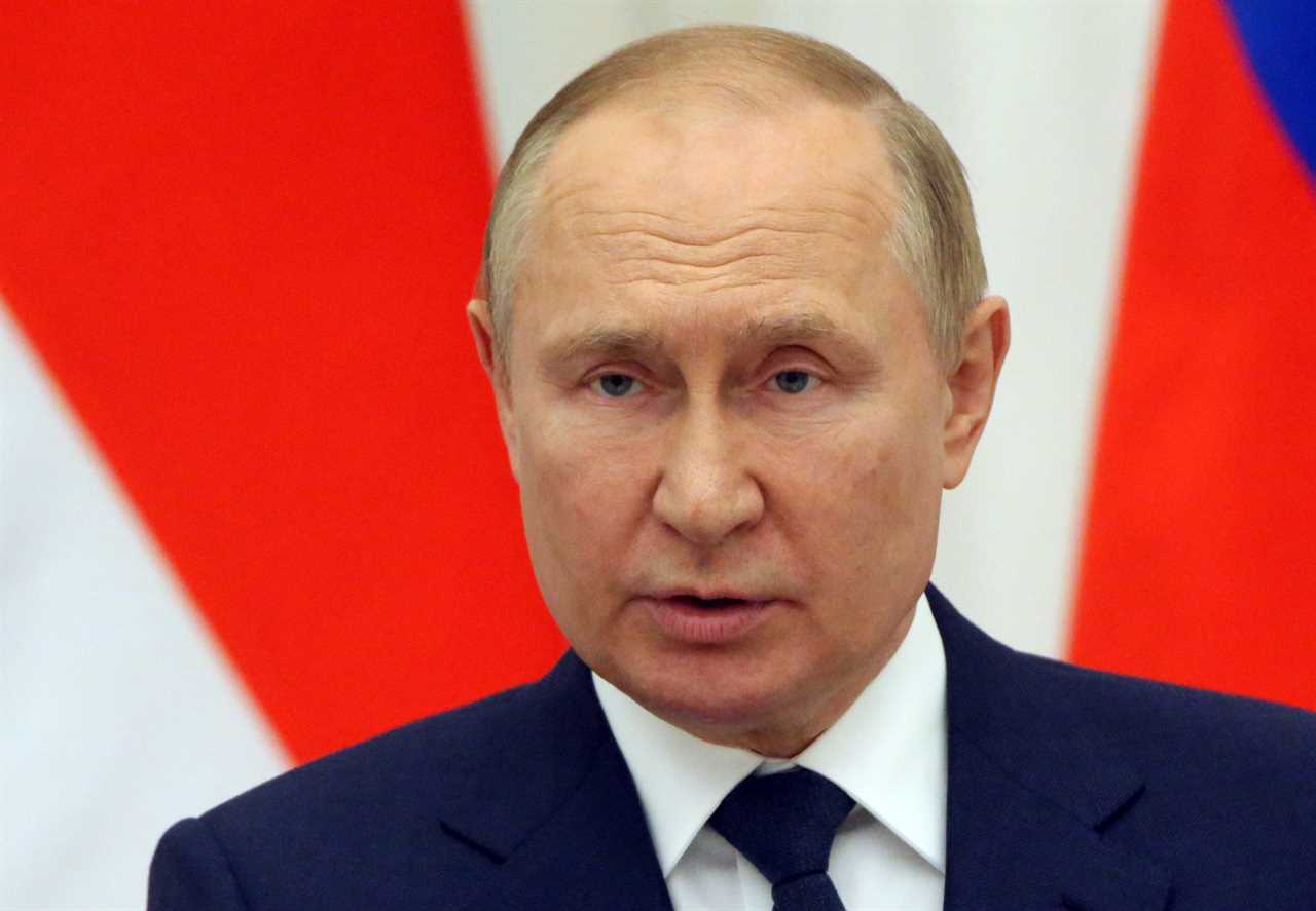 Russian President Vladimir Putin looks to the camera with a red and white striped background