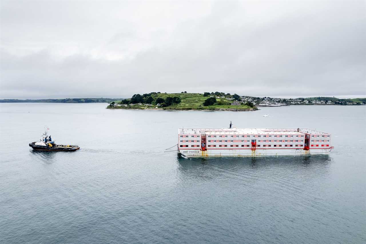 Huge three-storey barge that will house 500 migrants with a pool table and gym arrives in the UK