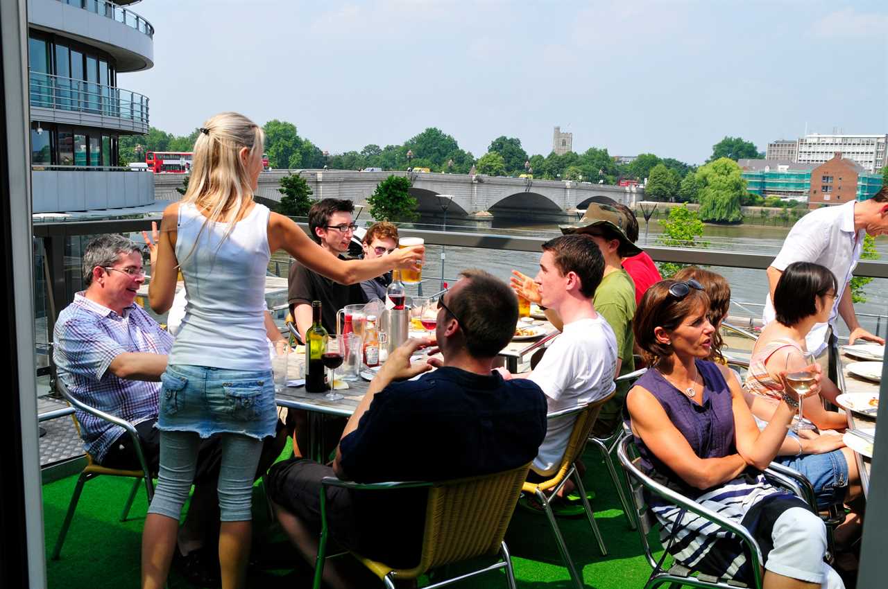 E0923Y Drinkers on the balcony of The Boathouse pub, Putney, London, England