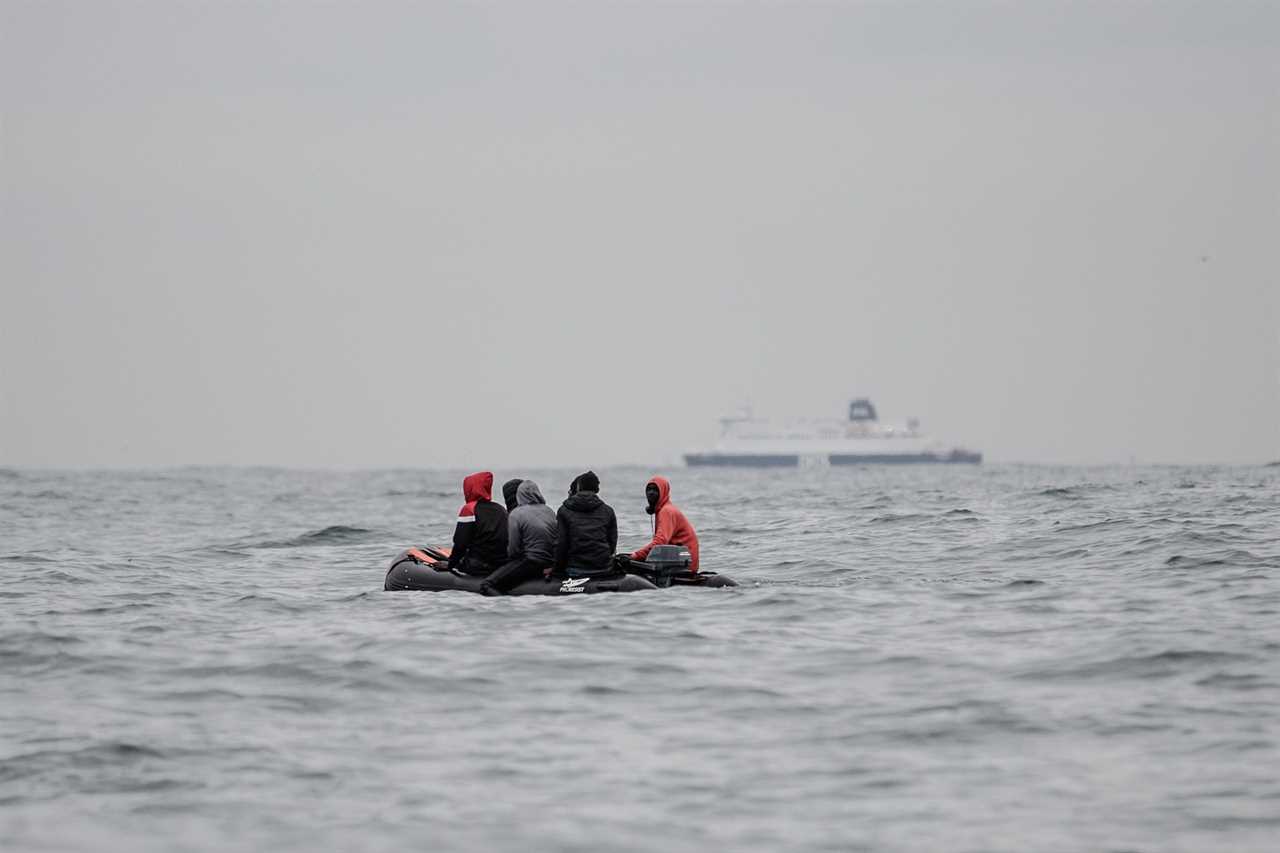 Migrants sit onboard a boat navigating in agitated waters between Sangatte and Cap Blanc-Nez (Cape White Nose), in the English Channel off the coast of northern France, as they attempt to cross the maritime borders between France and the United Kingdom on August 27, 2020. - The number of migrants crossing the English Channel -- which is 33,8 km (21 miles) at the closest point in the Straits of Dover -- in small inflatable boats has spiralled over the summer of the 2020. According to authorities in northern France some 6,200 migrants have attempted the crossing between January 1 and August 31, 2020, compared with 2,294 migrants for the whole of 2019. (Photo by Sameer Al-DOUMY / AFP) (Photo by SAMEER AL-DOUMY/AFP via Getty Images)