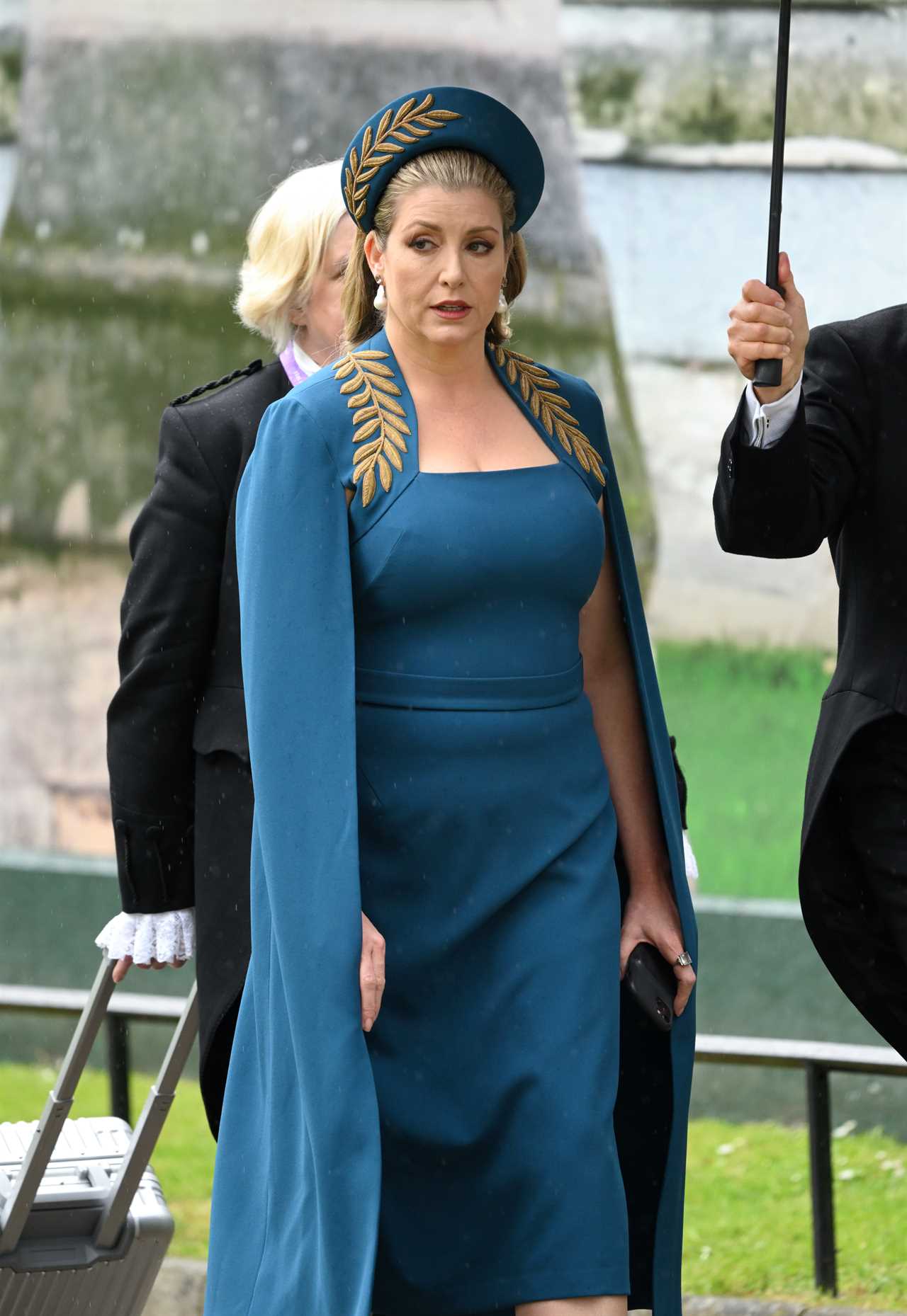 a woman wearing a blue cape and a gold hat